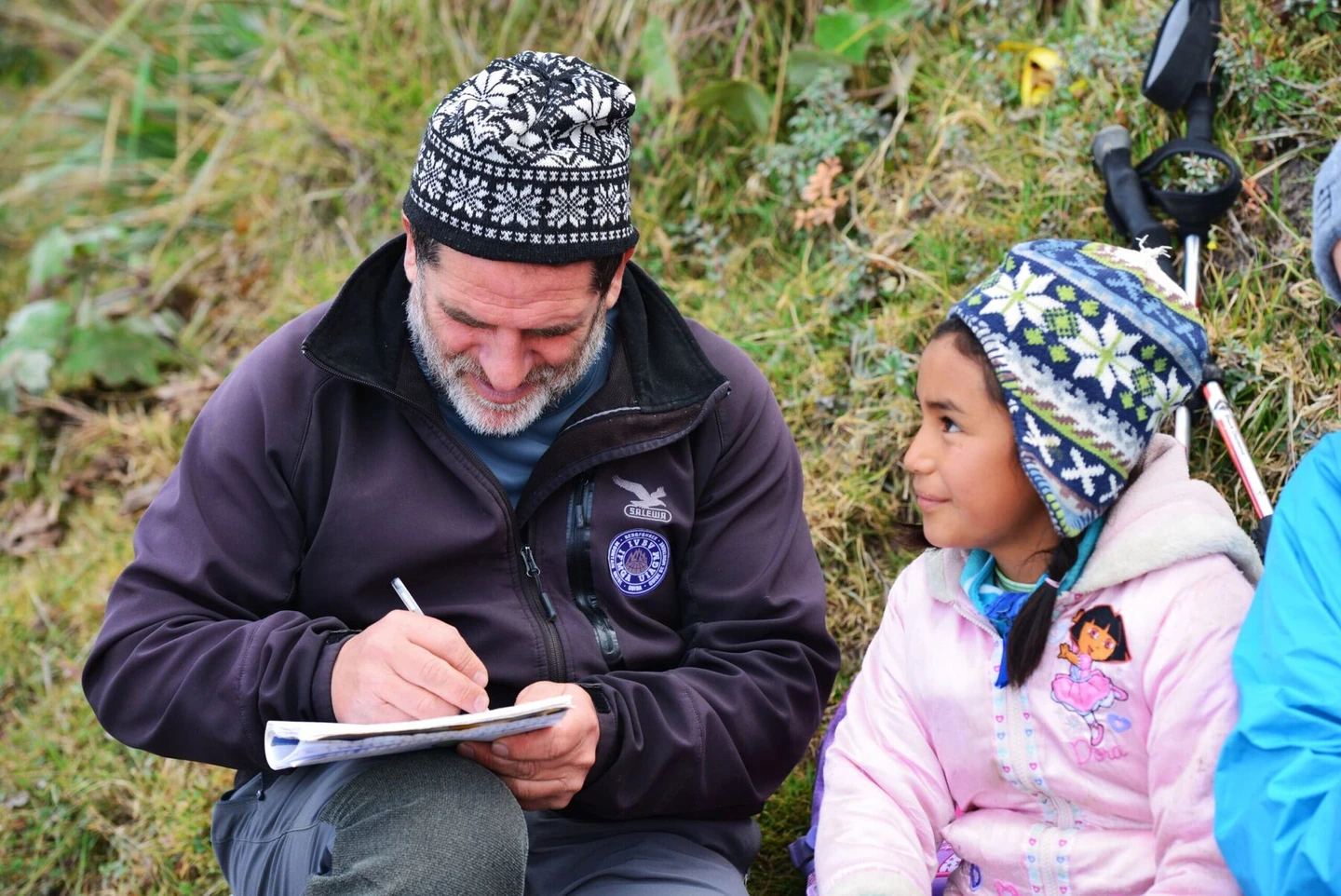 Franco Emmi prende appunti sul quaderno insieme a una bambina, durante un’escursione sull’Etna